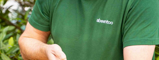 KI generiert: Person in grünem T-Shirt hält Pilz. Text: "abeentoo".