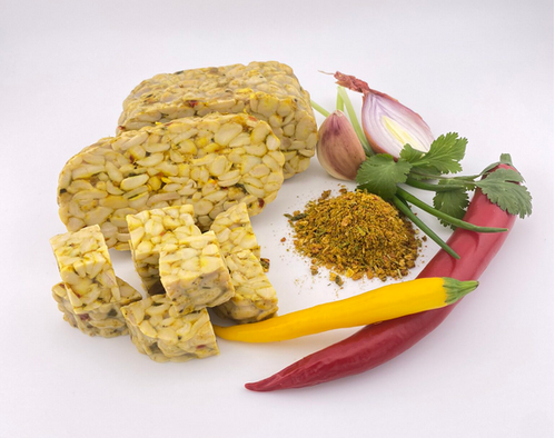 KI generiert: Tempeh, rote und gelbe Chilischoten, Schalotte, Koriander und Gewürzmischung.
