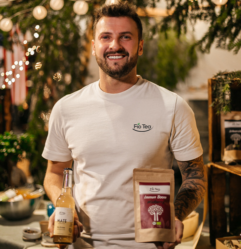KI generiert: Ein Mann hält Fio Tea Mate-Flasche und Immun Boom-Tee.