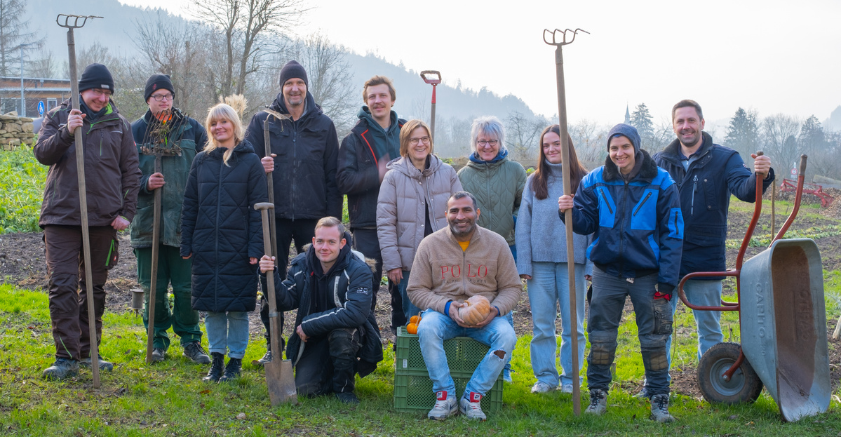 KI generiert: Eine Gruppe von Menschen posiert mit Gartengeräten auf einem Feld.